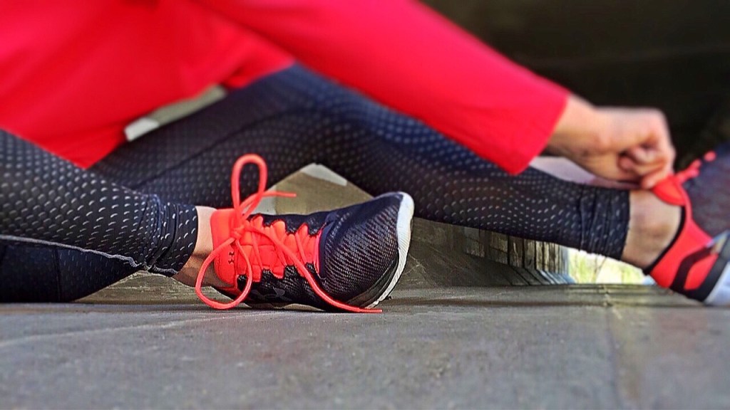 A woman ties the laces of her running shoes