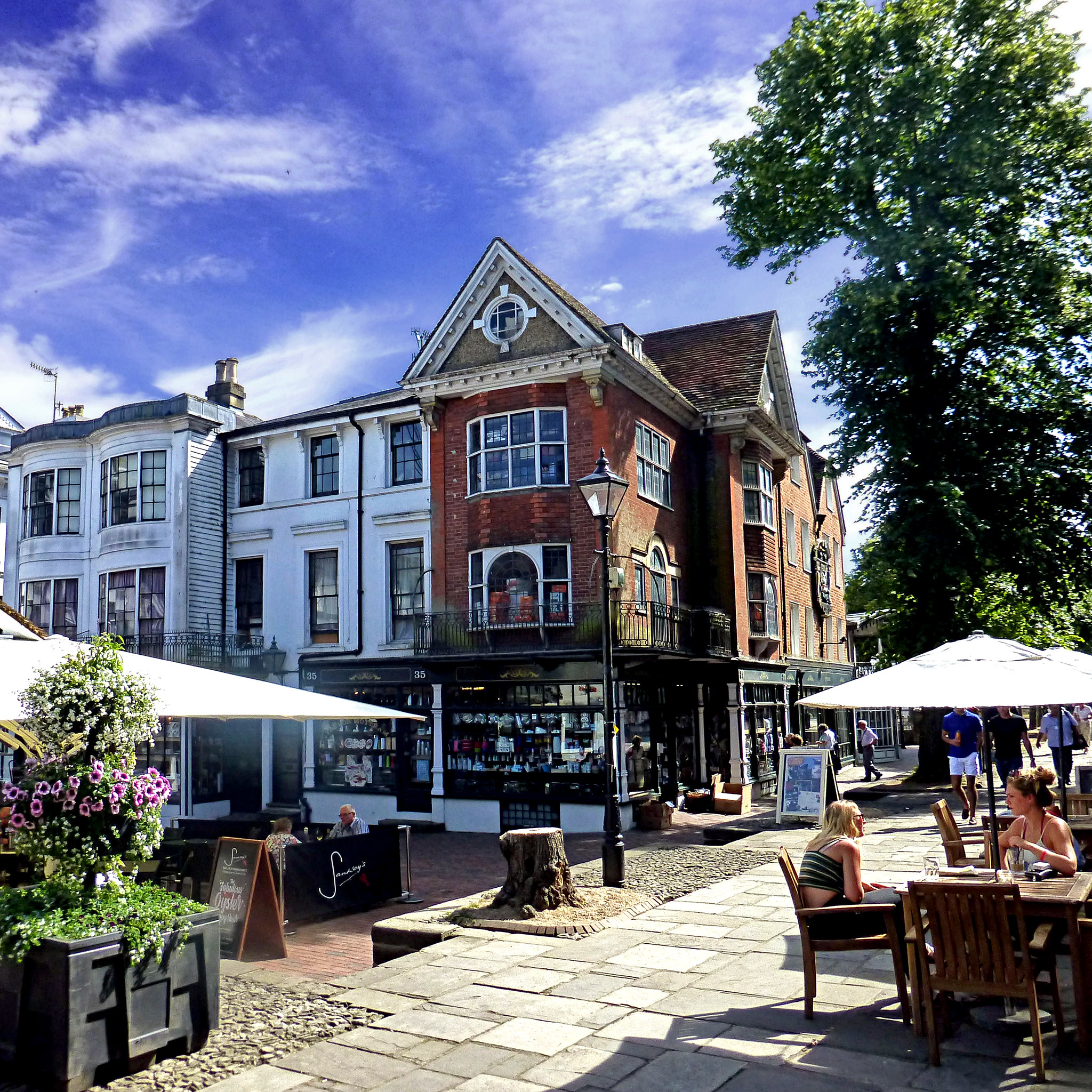 historic buildings in Tunbridge Wells with people sitting outside at tables.