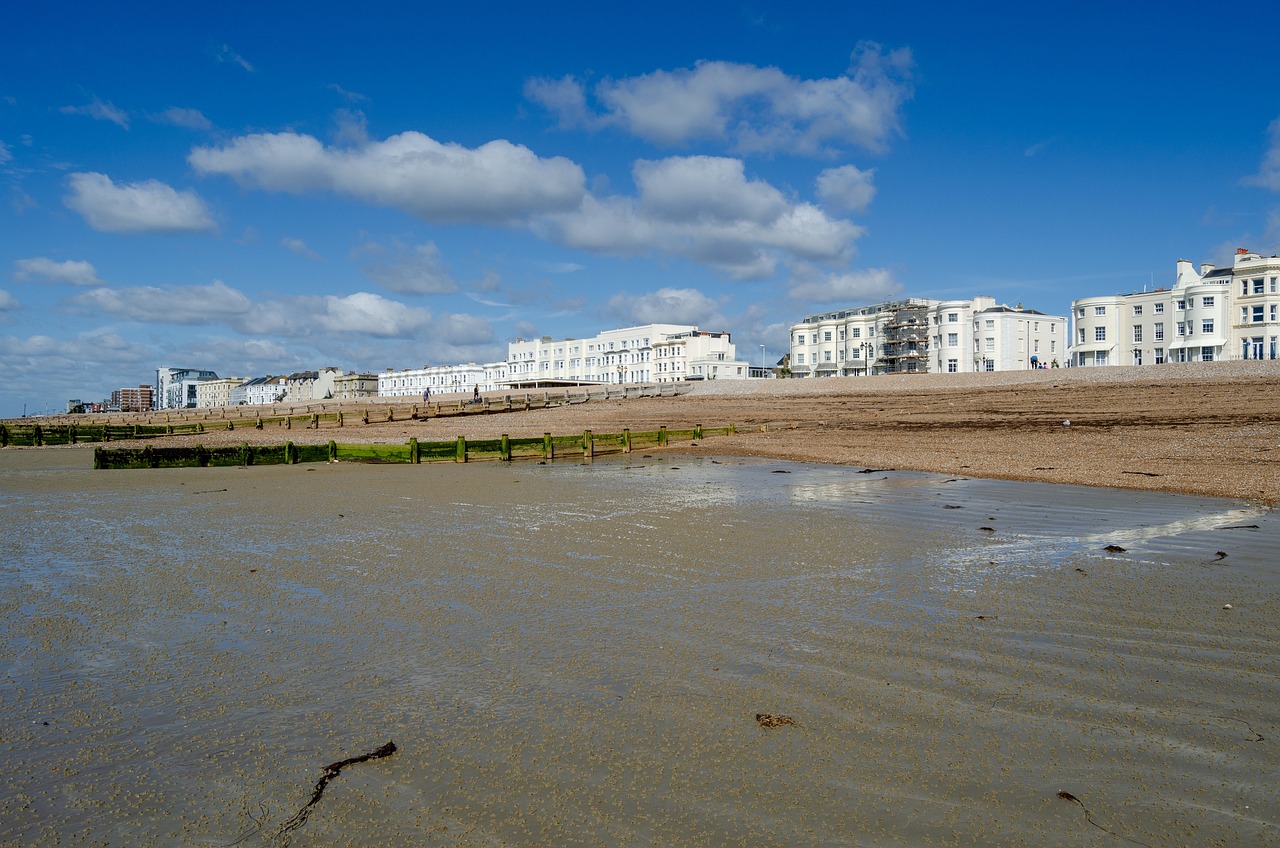 A beach with white period buildings along the back of it in Worthing.