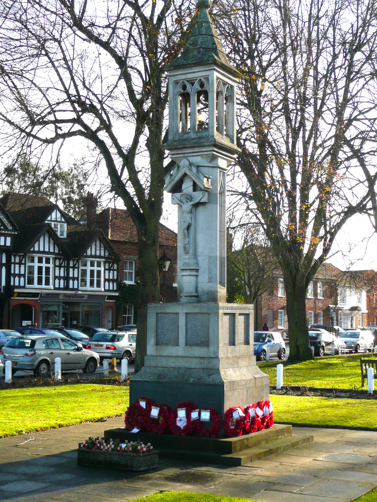 A stone war memorial with poppy wreaths at the base in Beaconsfield, Buckinghamshire.