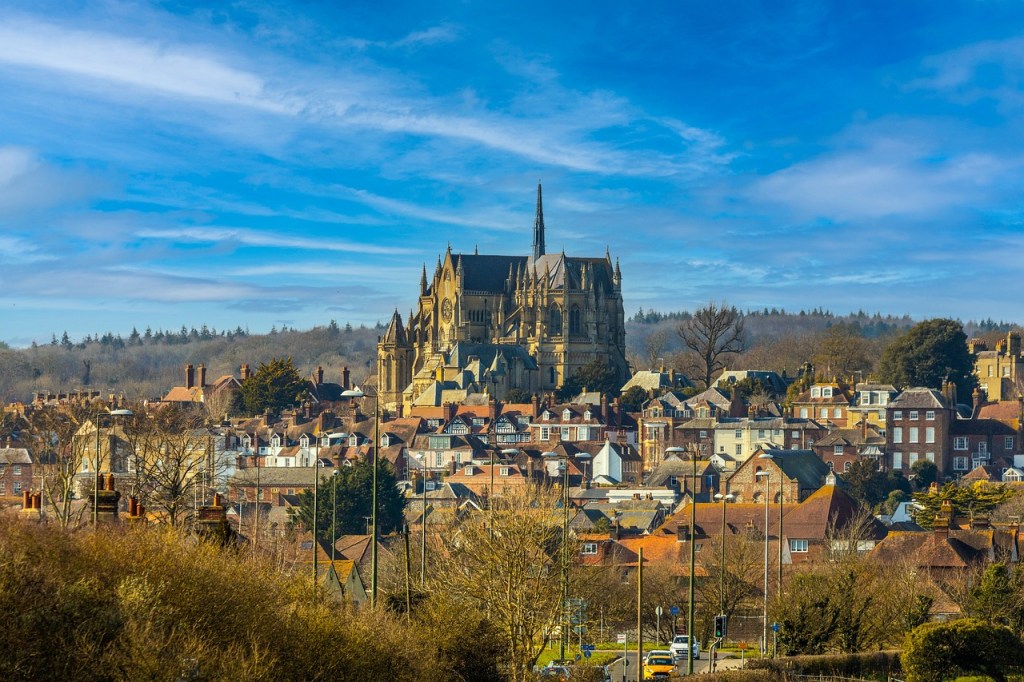 Aerial shot of Arundel, a town built on a hill with a cathedral on the top