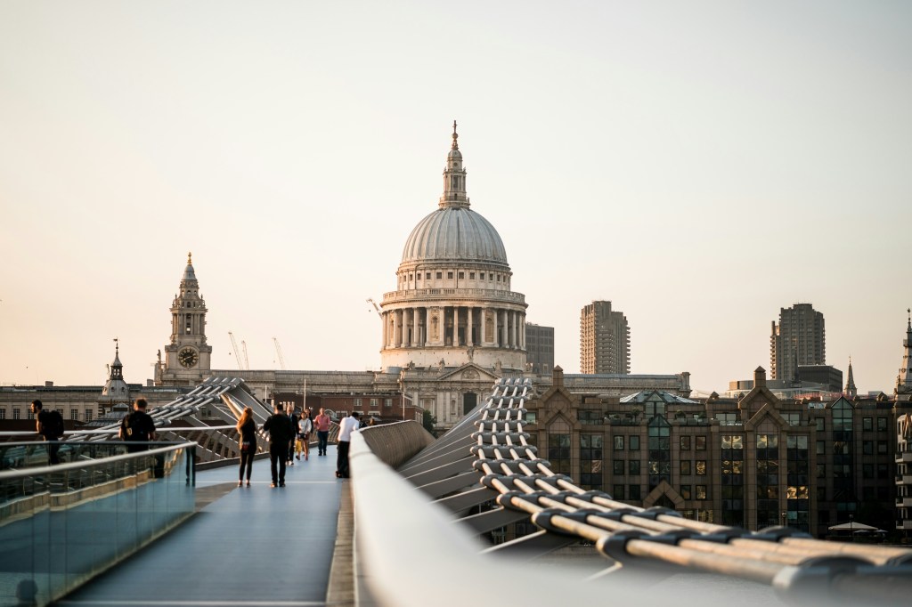 A view along a bridge to St Pauls cathedral with a huge dome in London