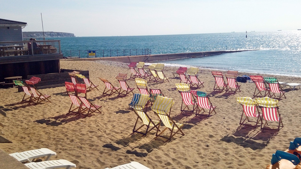 Striped deck chairs on a beach in the sunshine.