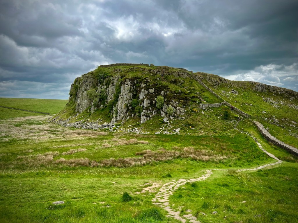 A view of Hadrian's Wall leading over rocky landscape.