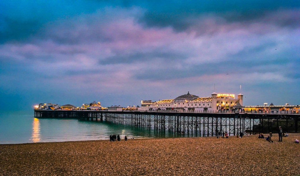 Brighton Pier at sunset with blue and purple clouds.