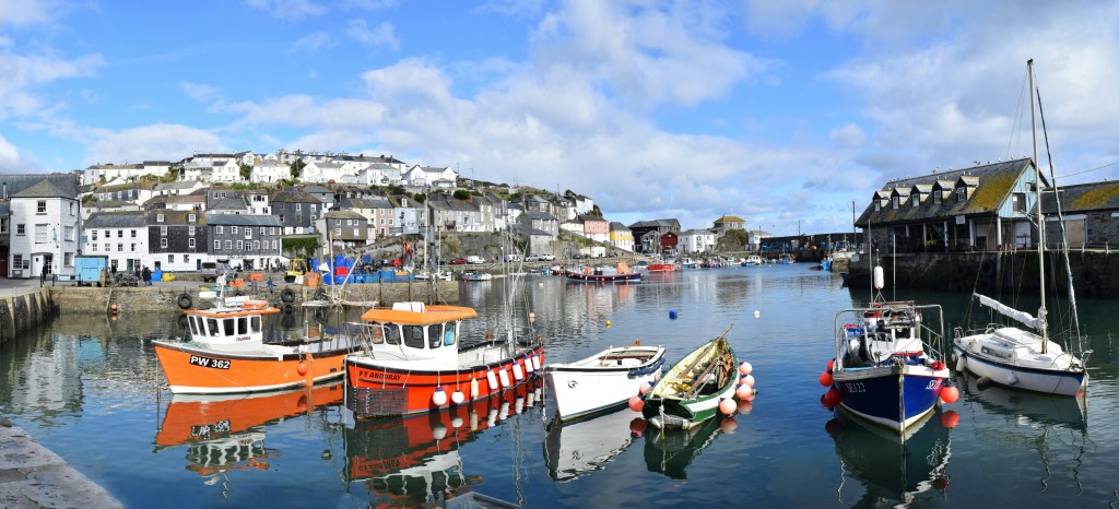 Fishing boats in the water at a Cornish fishing village.