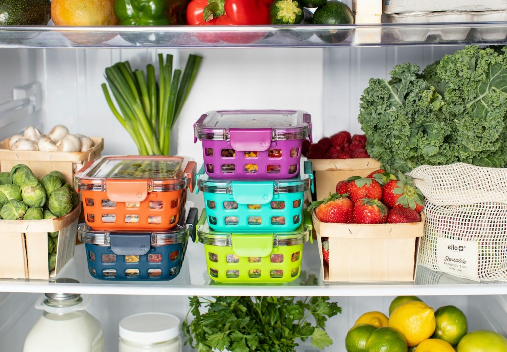 The shelves of a fridge with boxes of pre-prepped meals and vegetables.