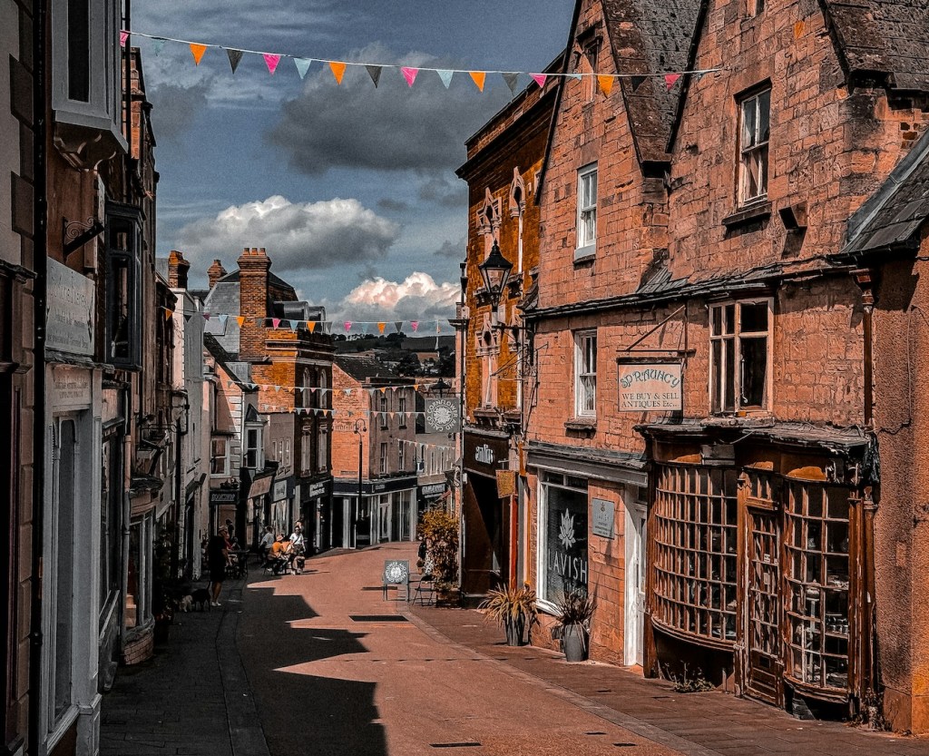 A view down a street in Stroud. The buildings are historic and there's bunting across the street.