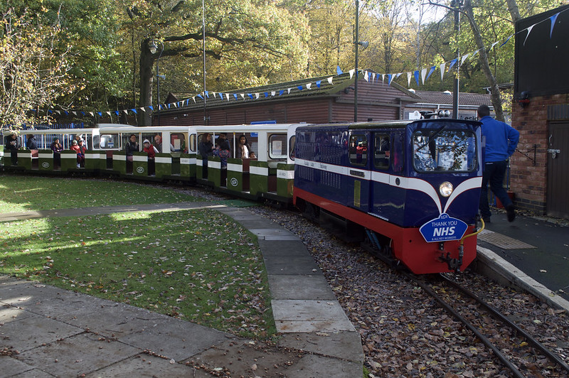 A miniature railway carrying happy passengers.