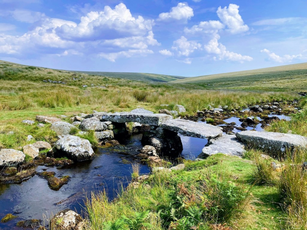 A stone bridge over a narrow waterway in Dartmoor National Park, Devon.