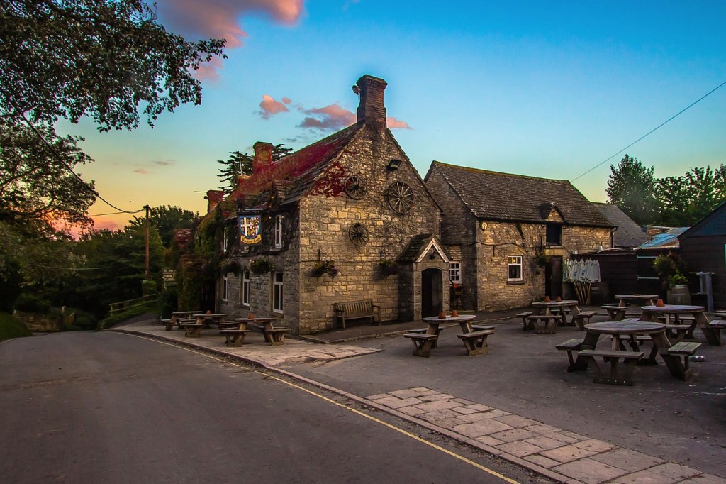 A countryside pub with benches outside.